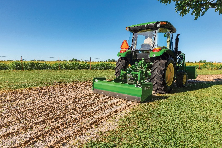 Compact Utility Tractor utilizing frontier attachment on a farm