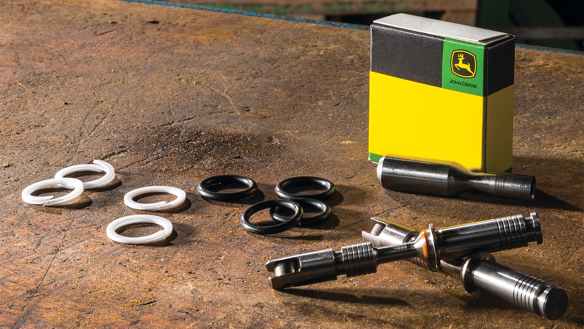 Genuine John Deere replacement parts and seal kit on a Koenig Equipment workbench
