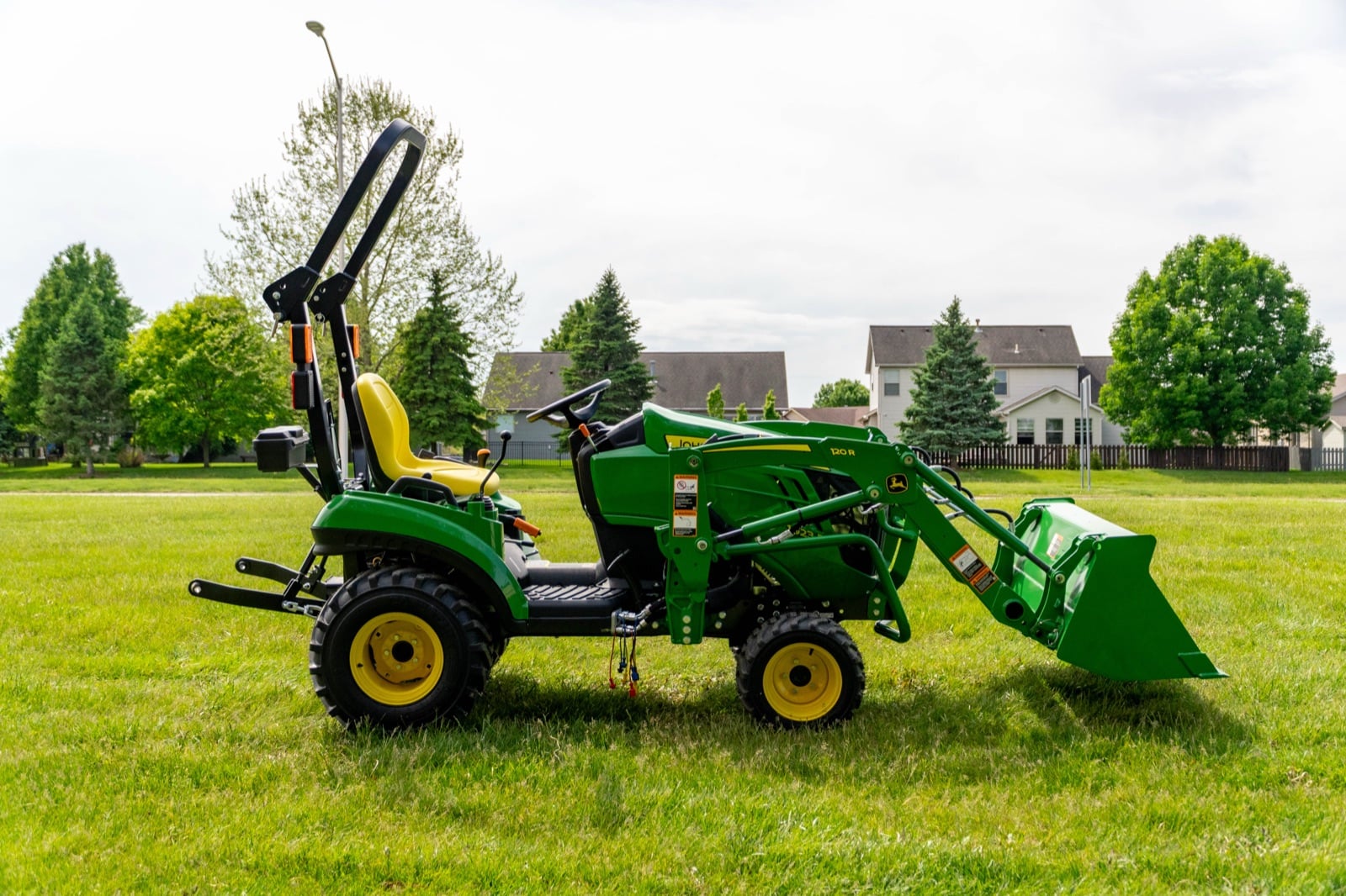 John Deere 1023E with a 120R loader on a lawn
