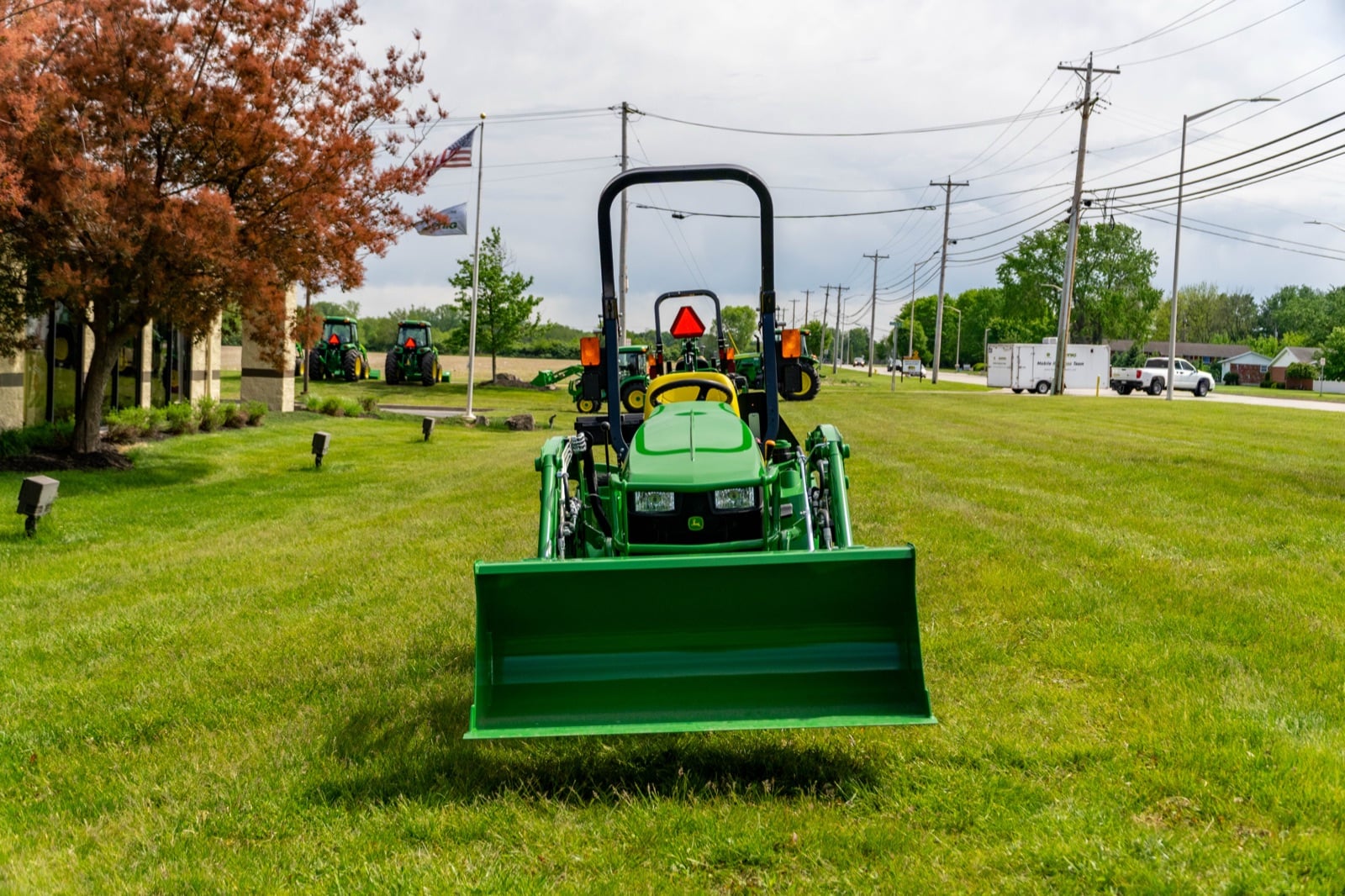 Front view of a John Deere 1023E with a 120R loader