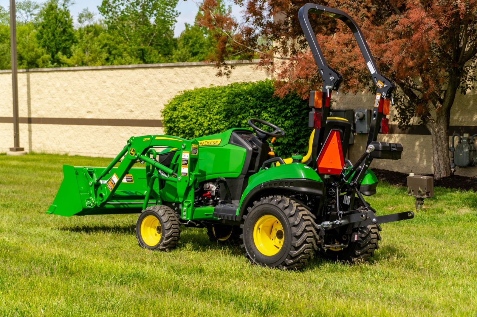 John Deere 1023E with a 120R loader, rear three-quarter view
