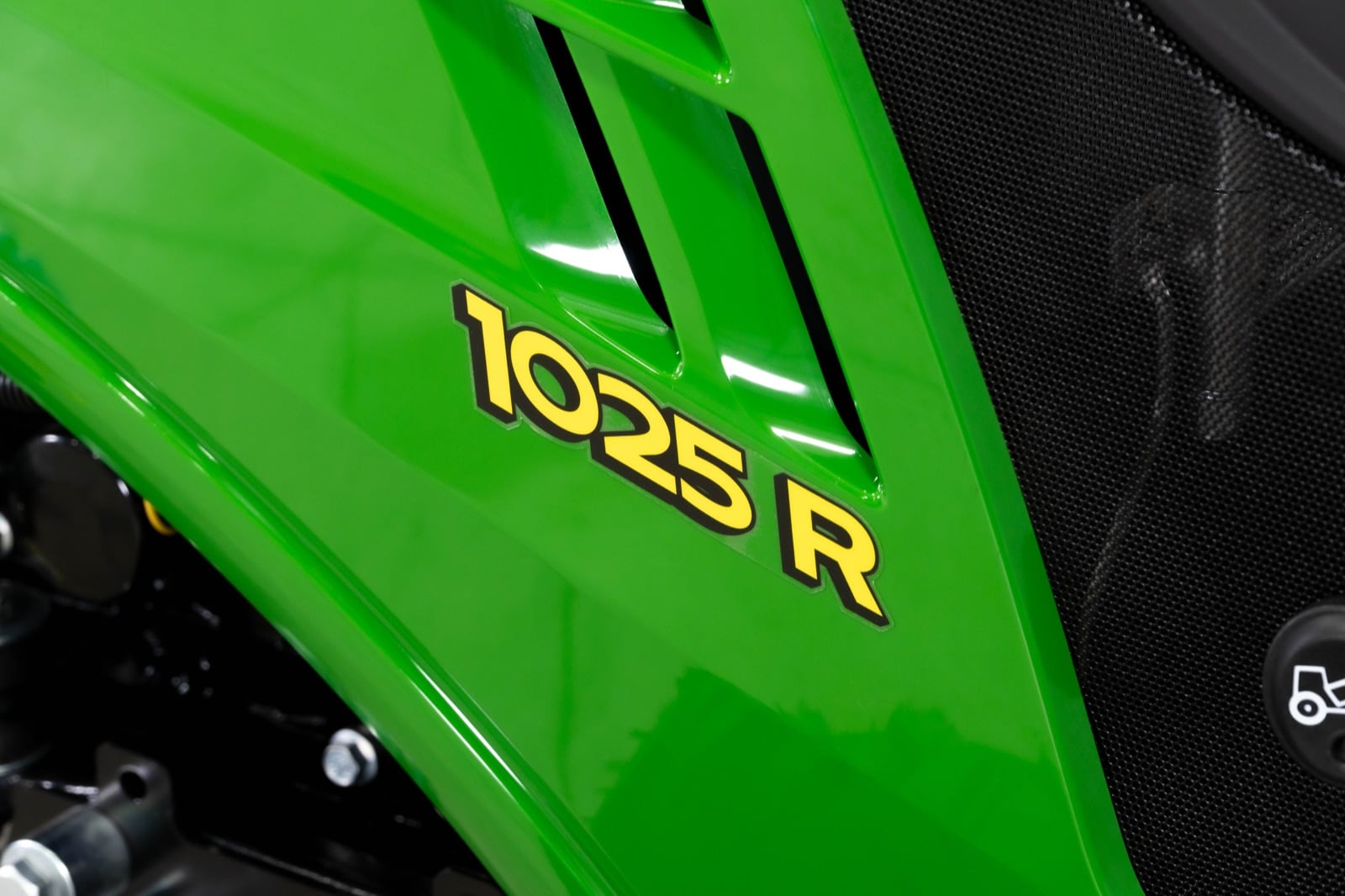 1025R badge on the hood of a John Deere compact tractor