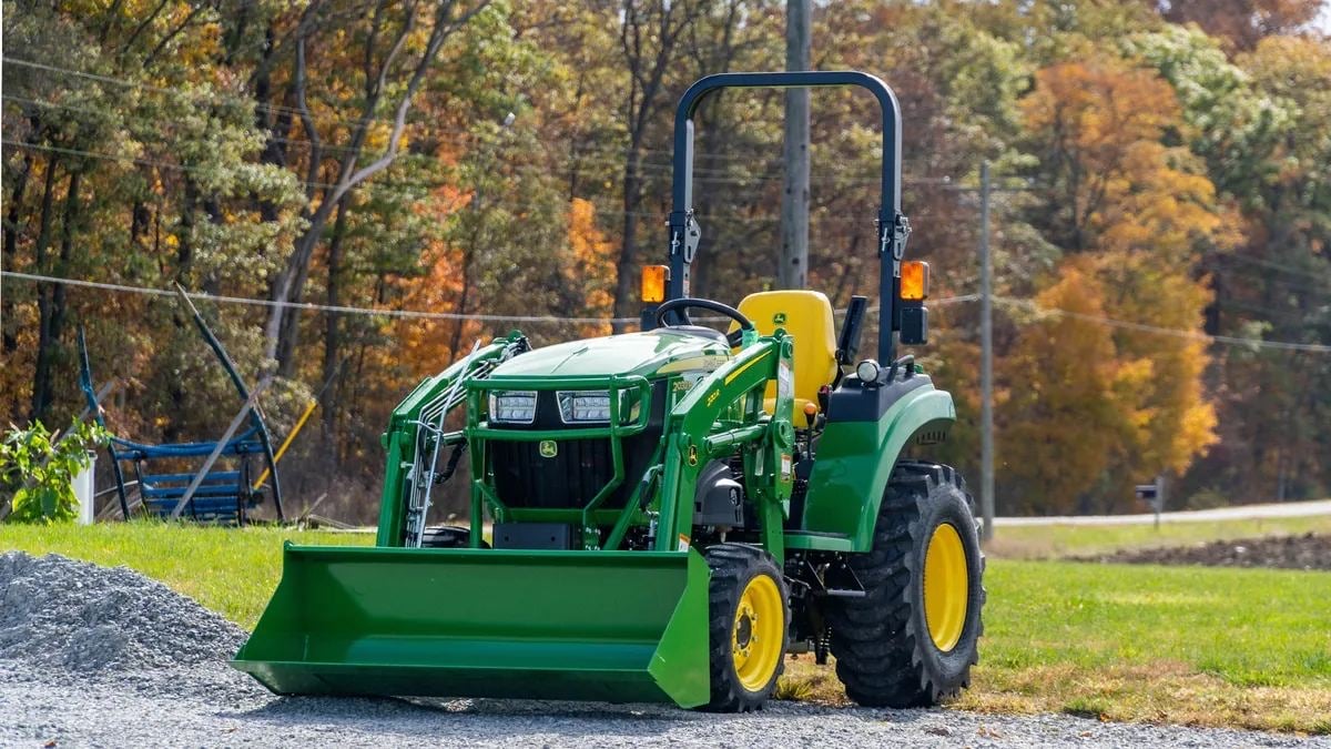 A John Deere 2 Family tractor with a loader on gravel
