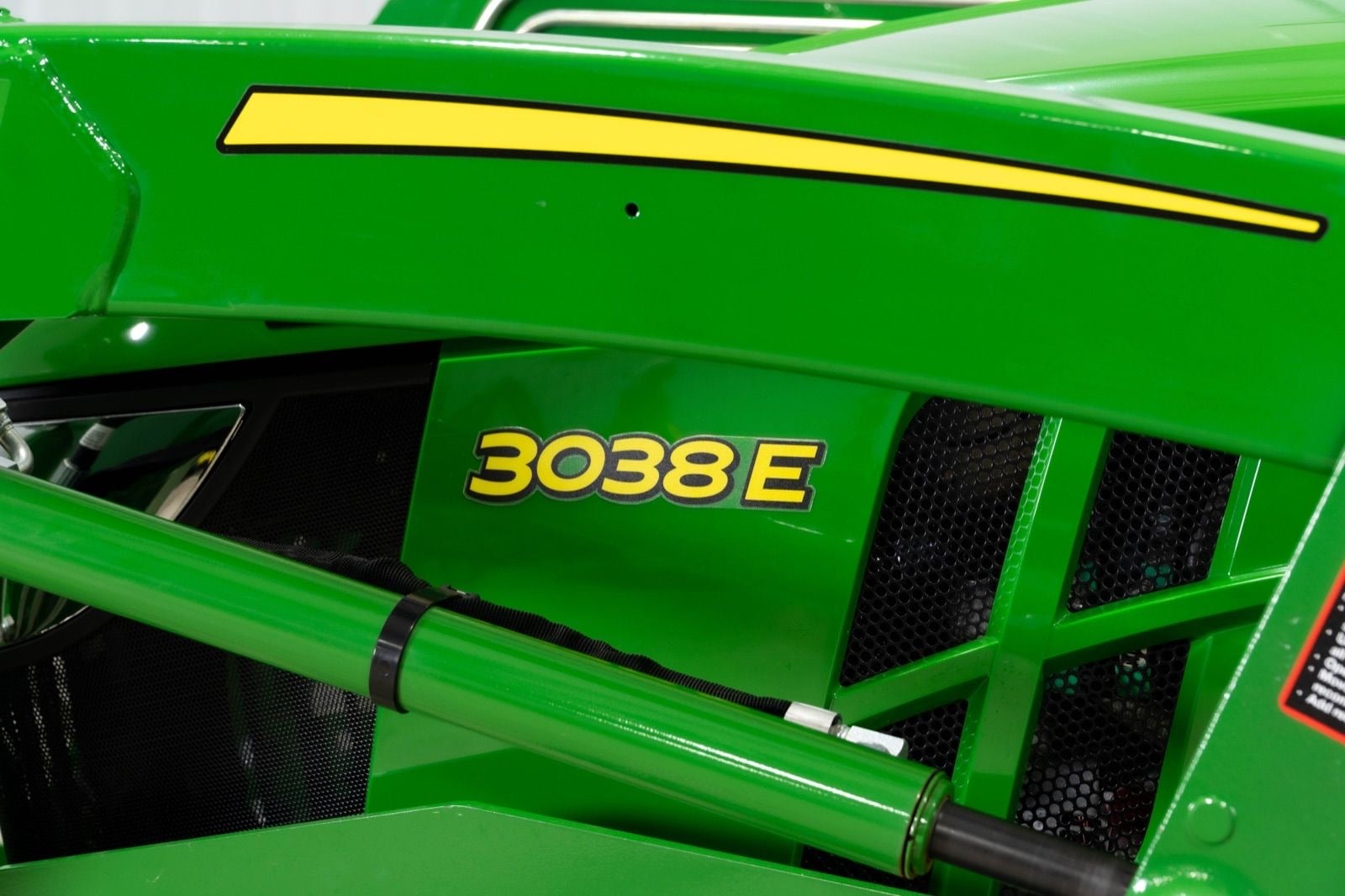3038E badge on a John Deere compact tractor