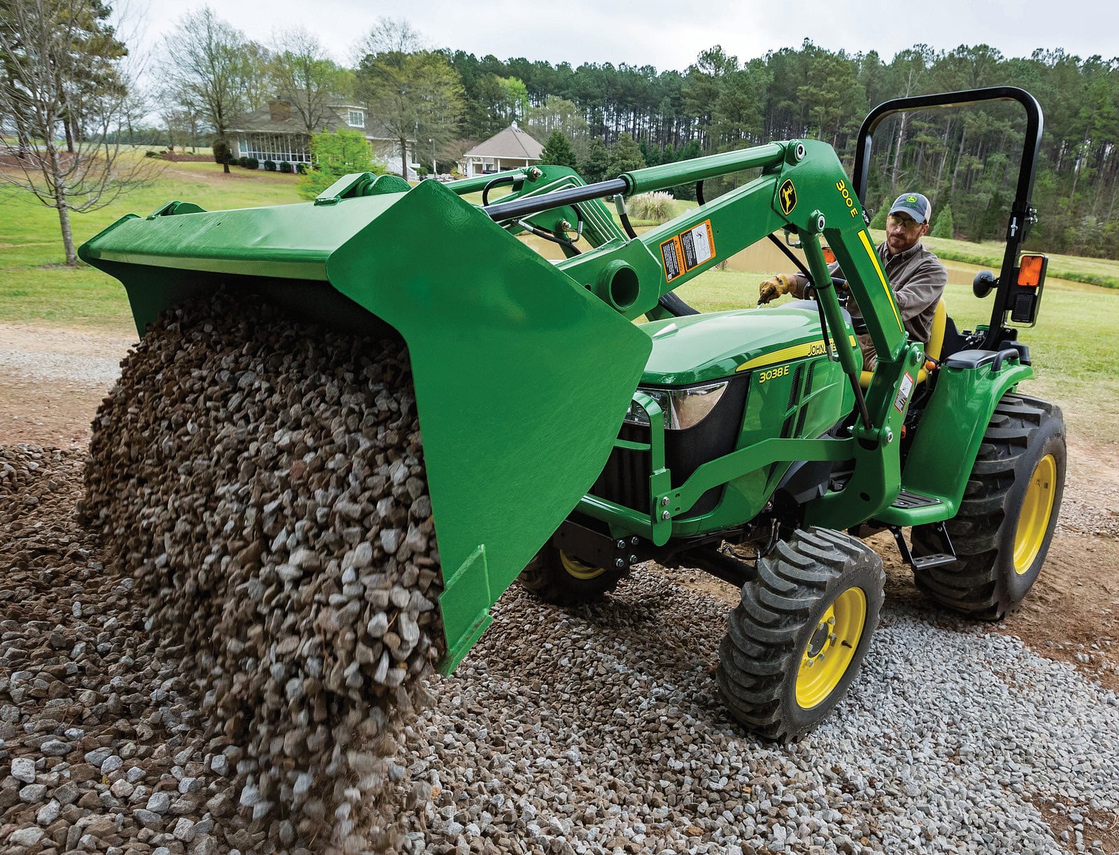A John Deere 3038E dumping gravel