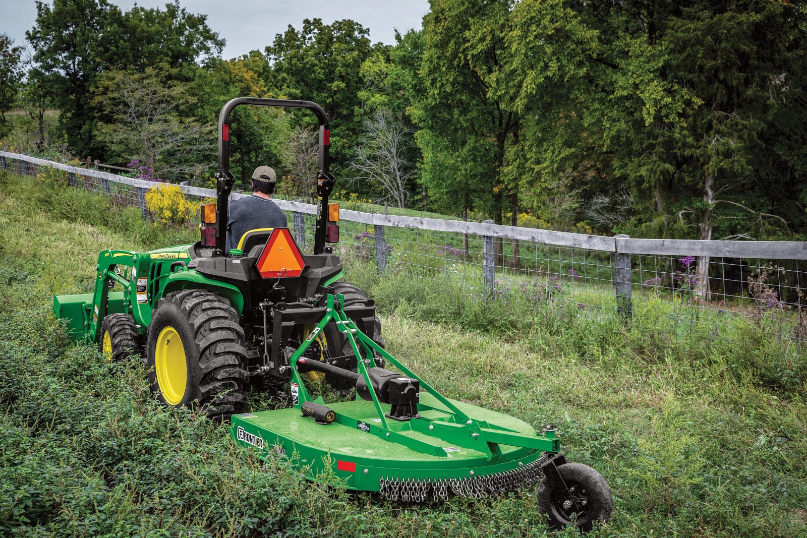 A John Deere 3032E with a rotary cutter
