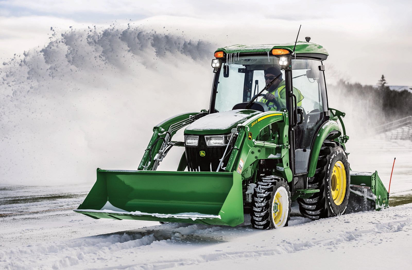 A John Deere 3046R clearing snow