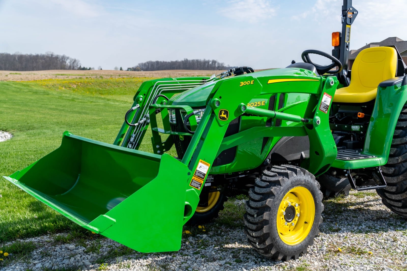 John Deere 3025E with a 300E loader, front three-quarter view