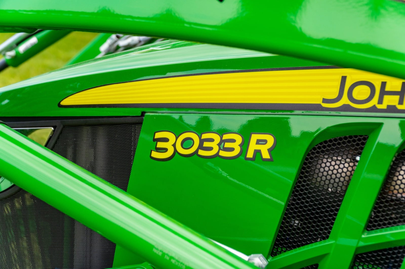 3033R badge on a John Deere compact tractor