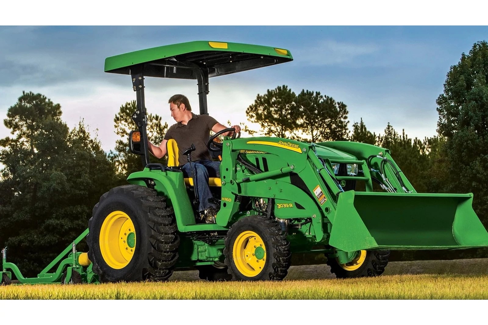 A John Deere 3039R with a loader in a field