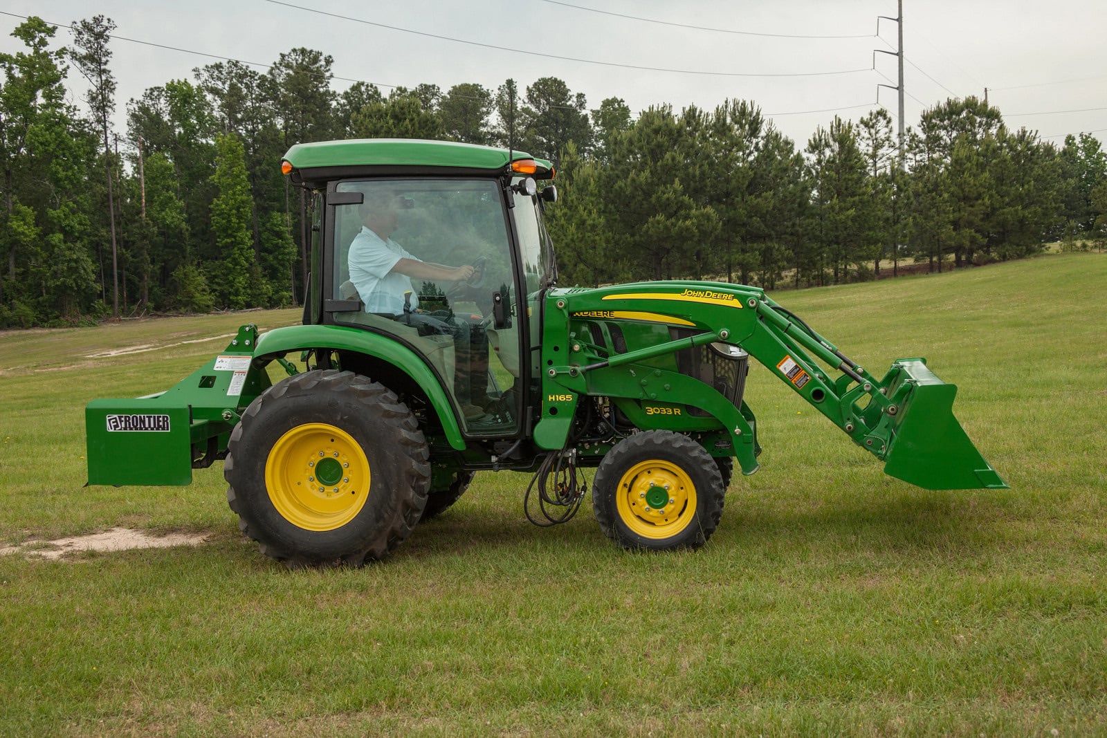 A John Deere 3033R cab tractor with a loader