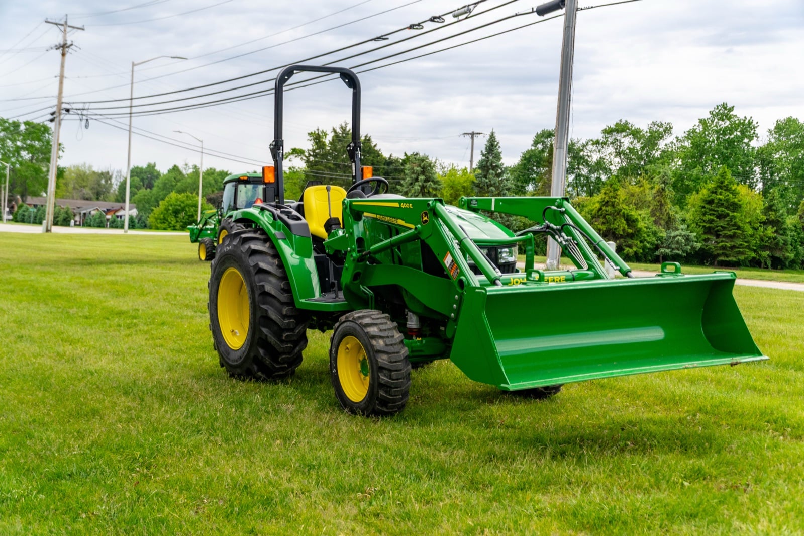 John Deere 4044M with a loader, front three-quarter view