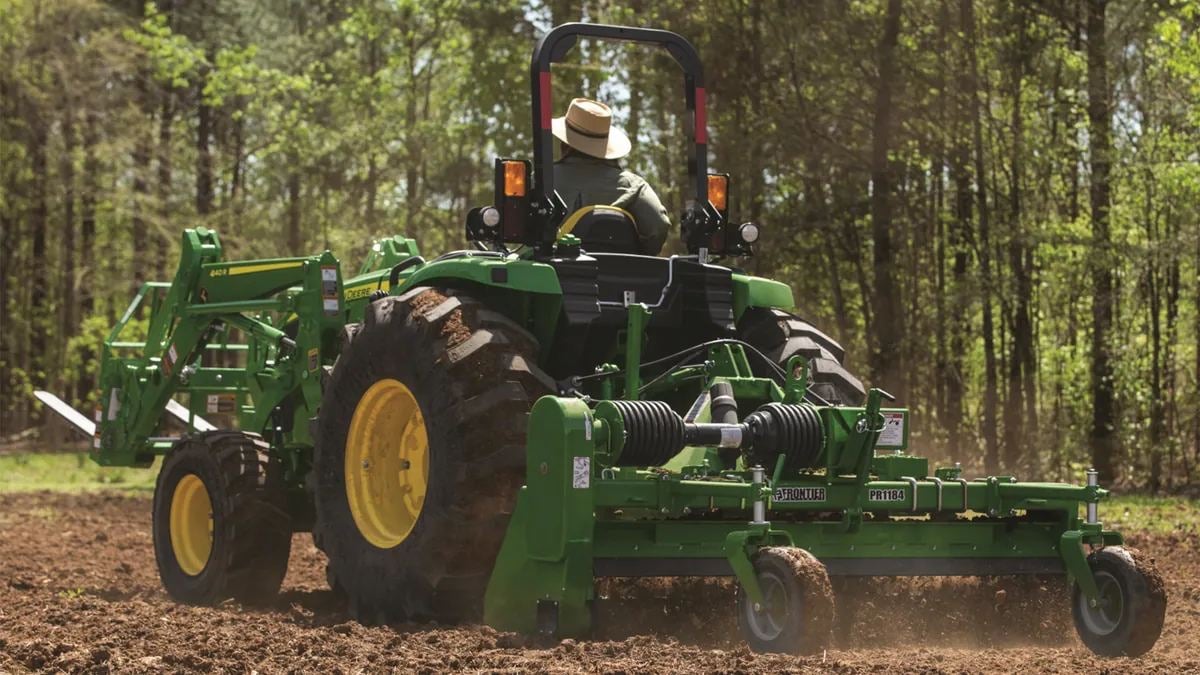 A John Deere 4 Family tractor with a rear implement