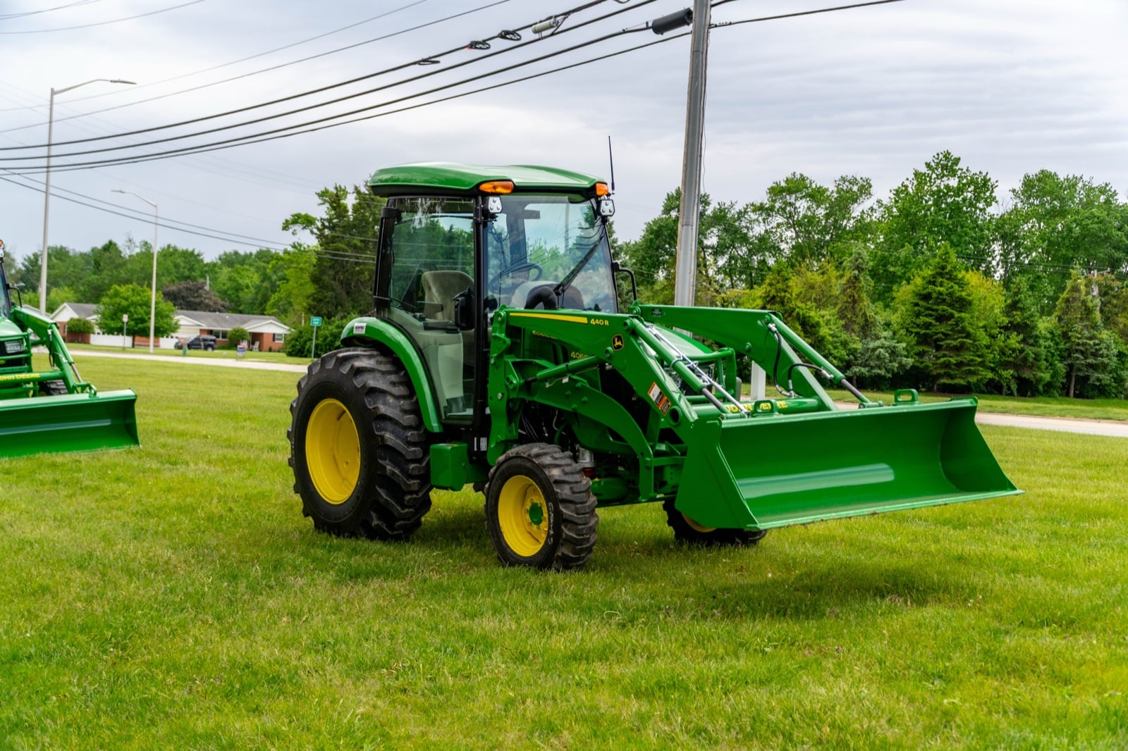 John Deere 4R Series tractor cab tractor with a loader, front three-quarter view (4066R shown)