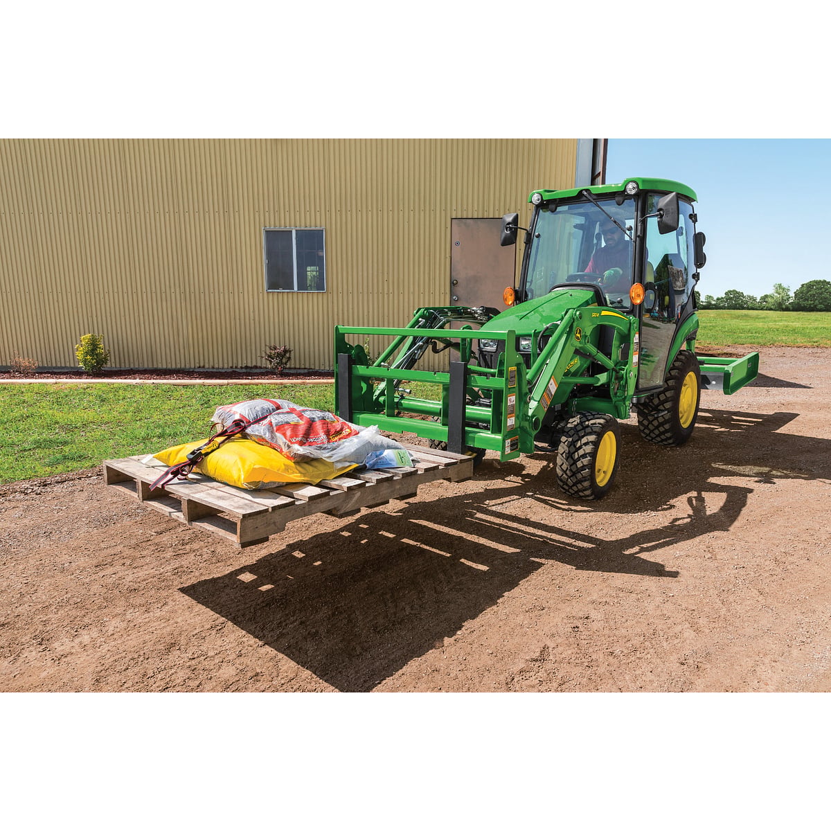 2025R Compact Tractor Carrying Materials on a Pallet Fork