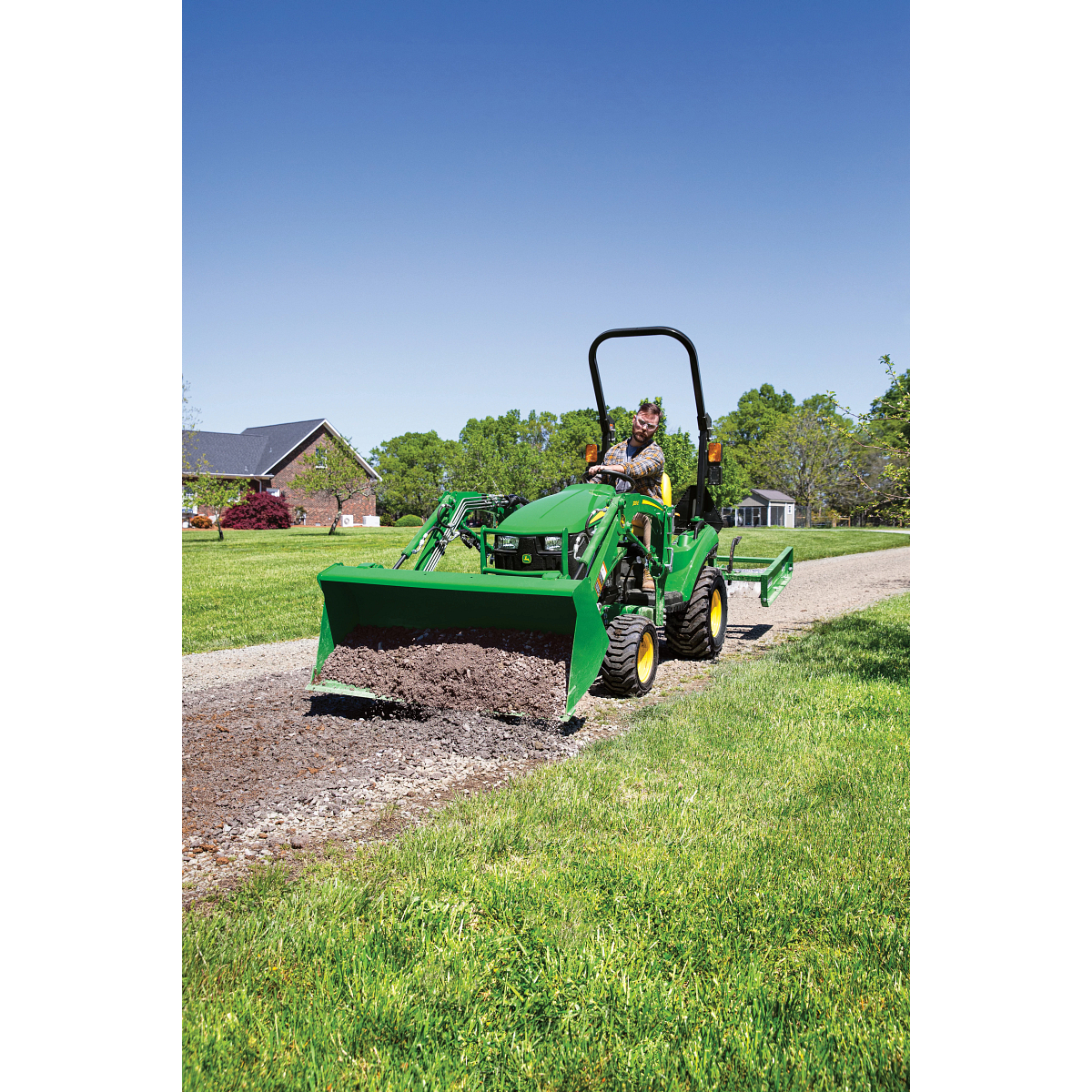 1023E Compact Tractor Spreading Gravel on a Driveway