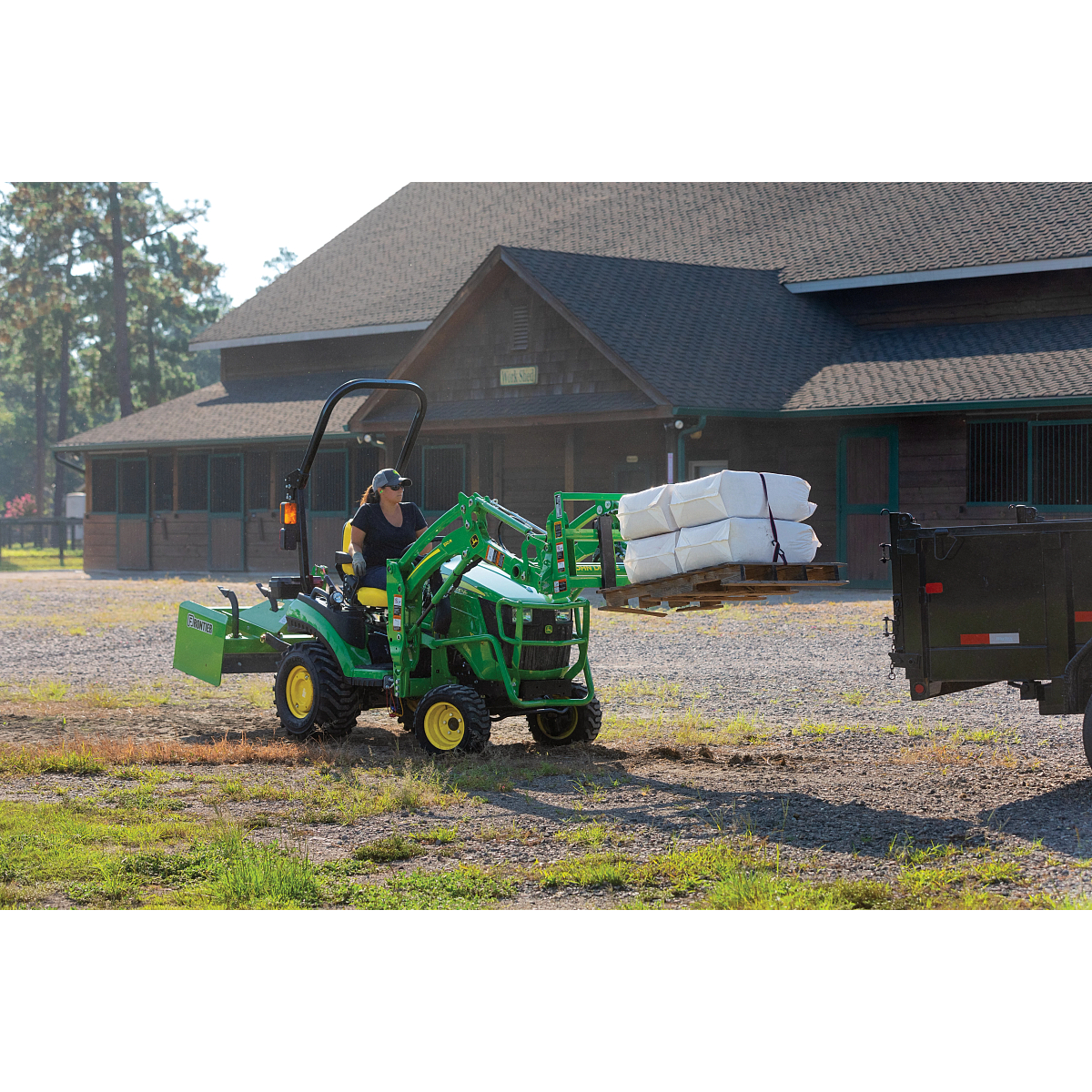 1023E Compact Tractor Hauling Materials with Pallet Fork