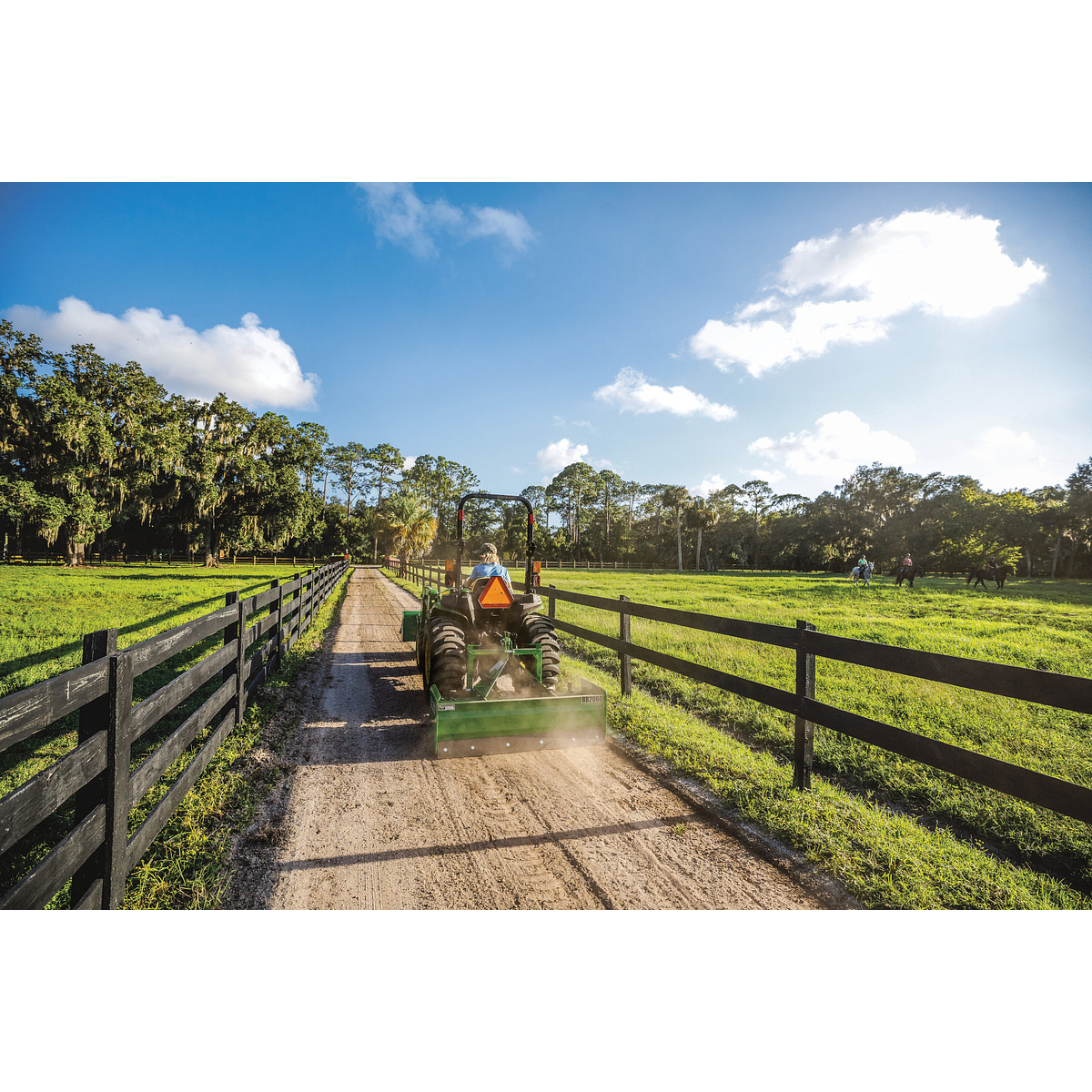 3032E Compact Tractor With Rear Land Plane on a Dirt Lane