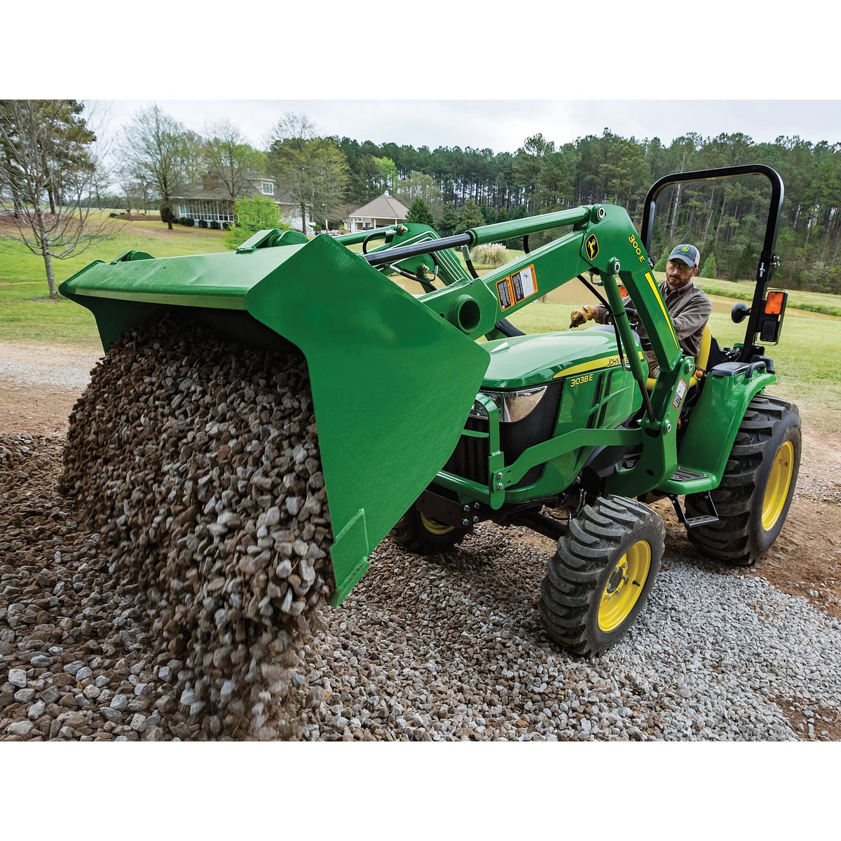 3038E Compact Tractor With Front Loader Dumping Gravel